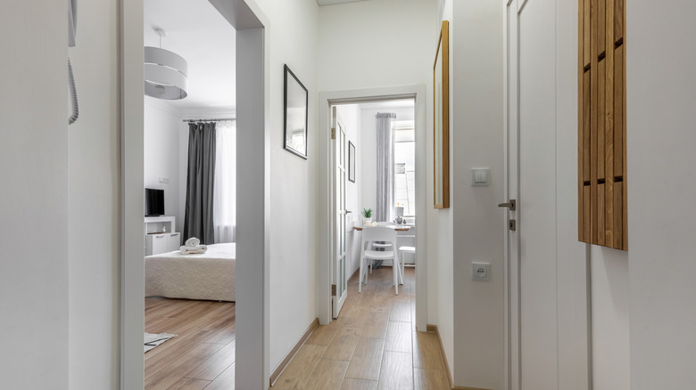 Narrow hallway in a home with a mirror on the wall