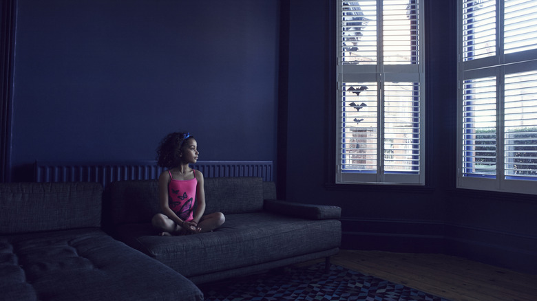 Child sitting on a sofa in a navy living room