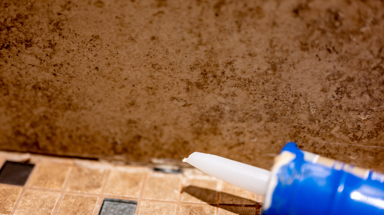 caulk tube laying beside shower joint