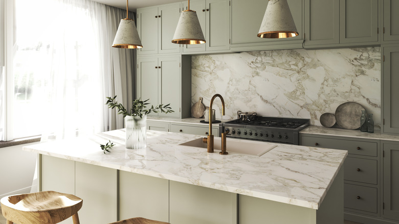 Open-style green and white kitchen with marble countertops