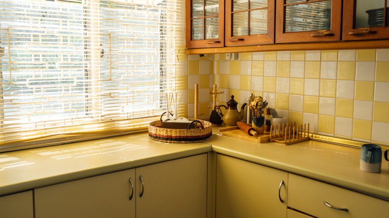 A retro yellow kitchen with metal countertops, cabinets, and vintage decor