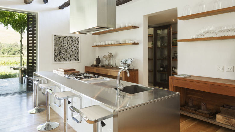 Open kitchen with a stainless steel kitchen island and wooden accents