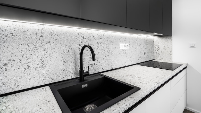 Black and grey kitchen with black accents and terrazzo countertops