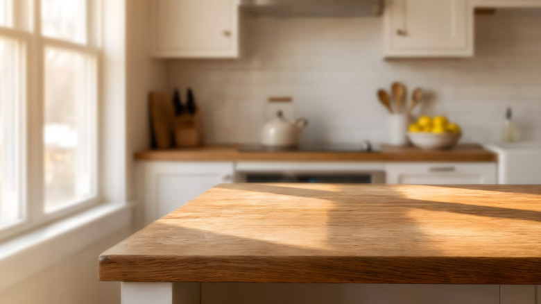 Close up of a light wooden countertop in a sunny kitchen
