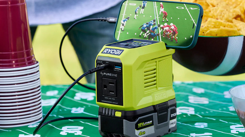 Ryobi 18V ONE+ Power Source/Charger on a table charging a cell phone for game day