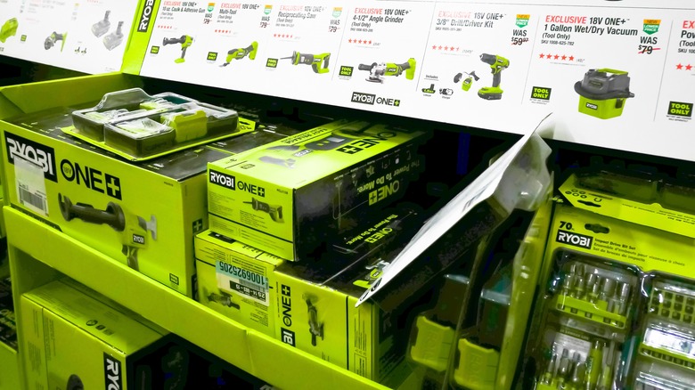 Ryobi batteries and tools on a shelf at a home improvement store.