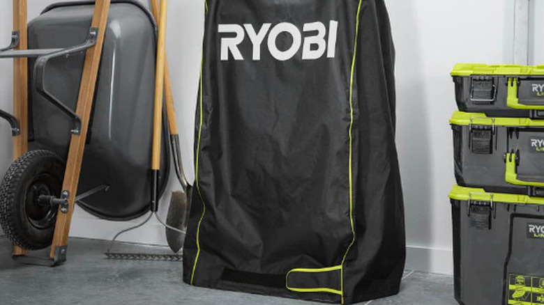 The RYOBI lawn mower cover in a garage.