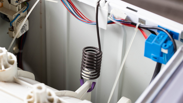 A close up of a suspension spring inside a washing machine.