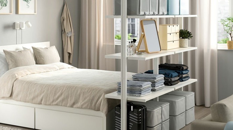An bedroom is divided in two using an ELVARLI shelving system