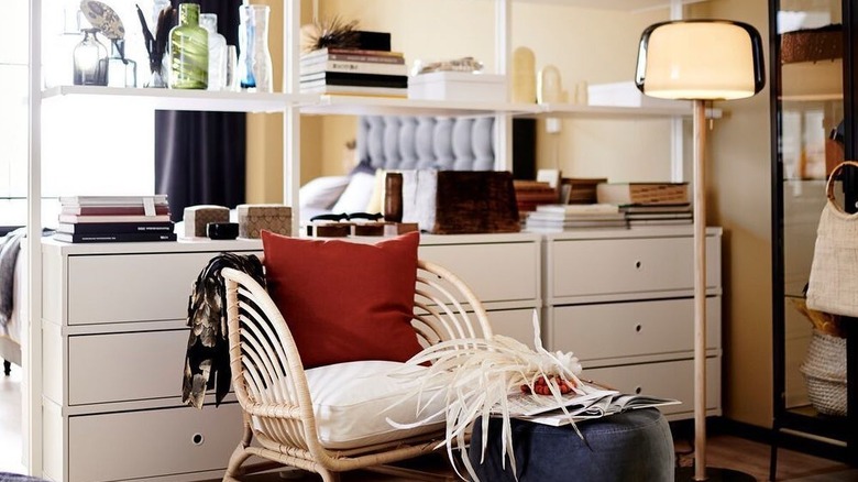 A chic getting-ready station made with ELVARLI shelving holding shoes, sunglasses, cologne, lamps and plants.
