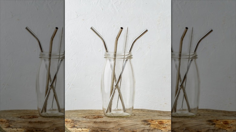 Metal straws in a clear glass vase