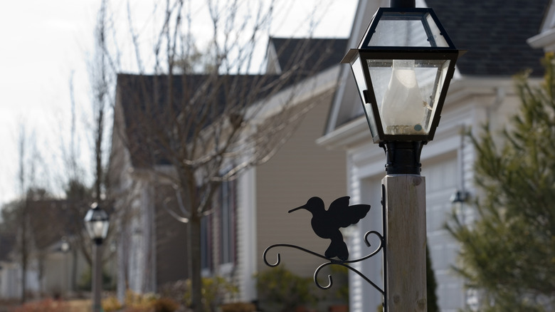 A house's lightpole with a hummingbird design on it.
