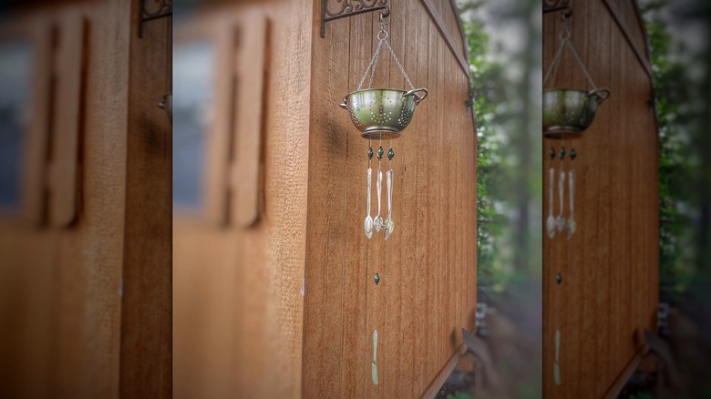 hanging wind chime made of a colander and old metal utensils