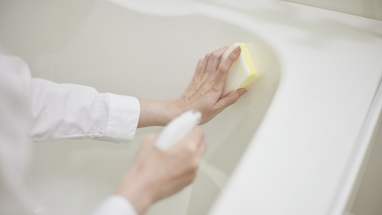 Closeup of person cleaning bathtub