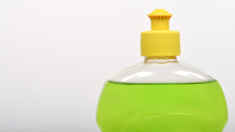 Close up of green dish soap in a bottle with yellow cap