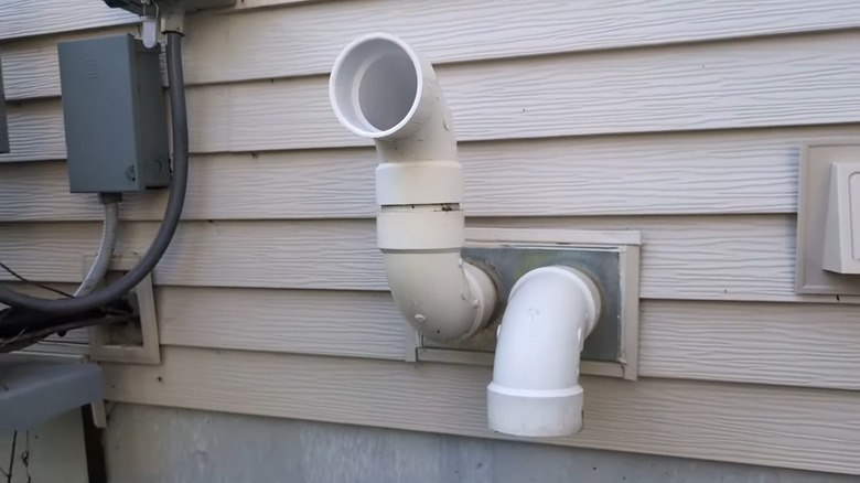 View of an exhaust and intake pipe for a furnace on the side of a home