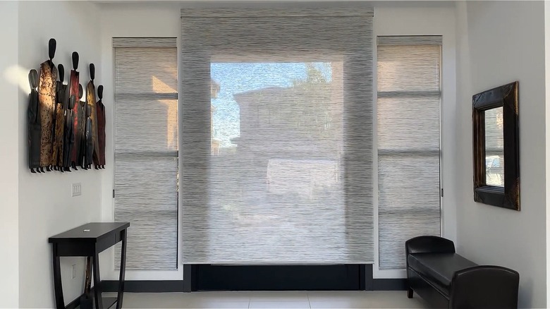 Grey woven roller shades over a large glass front door
