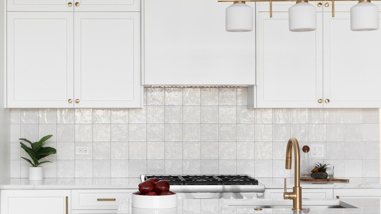 A white zellige tile kitchen backsplash with monochrome white grout