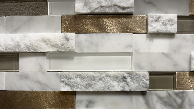 Stacked tile backsplash including stone, ceramic, and glass