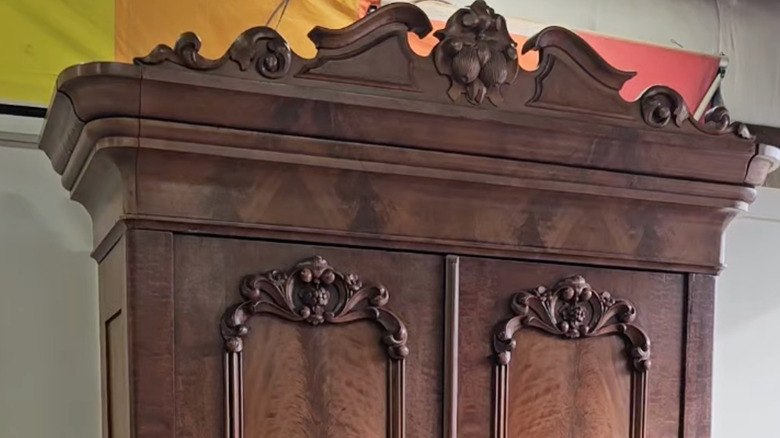 American Empire armoire from 1818 with carved detailing on the top and on the doors
