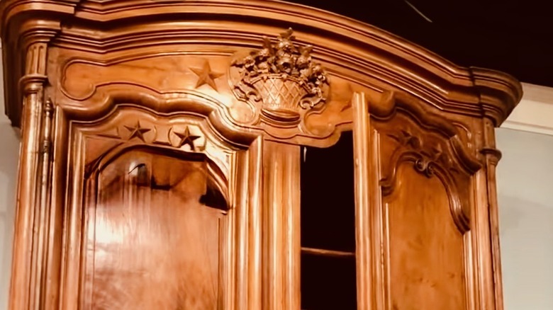 A huge and grand armoire in the French Provincial style with ornately carved detailing