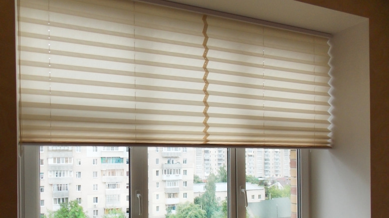 Close up on half-raised accordion blinds.