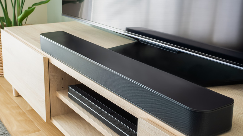 A close up of a TV and sound system on a pine unit.