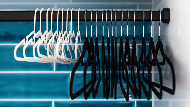 A set of matching white hangers and matching black velvet hangers.