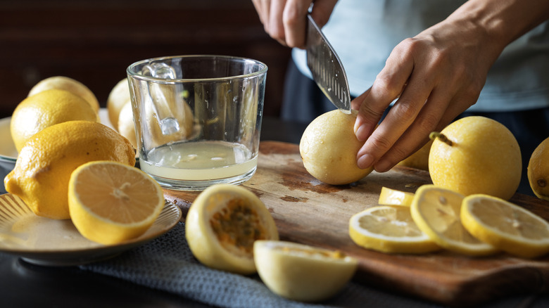 A person slicing and juicing lemons