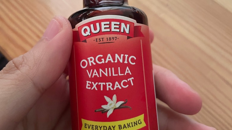 holding a bottle of vanilla extract