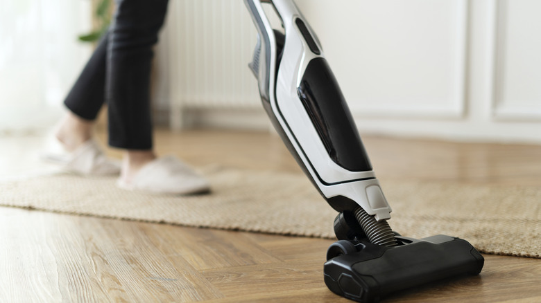 Person pushing a vacuum on floor