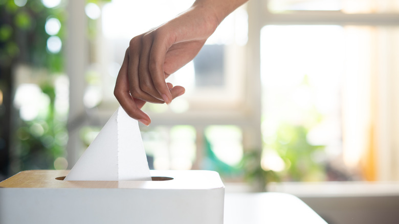 Person grabbing a tissue out of a tissue box