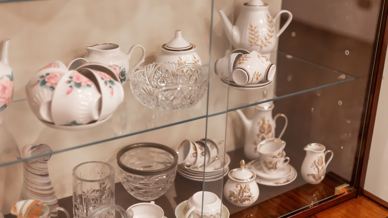 Close up of vintage porcelain items kept in glass cabinet