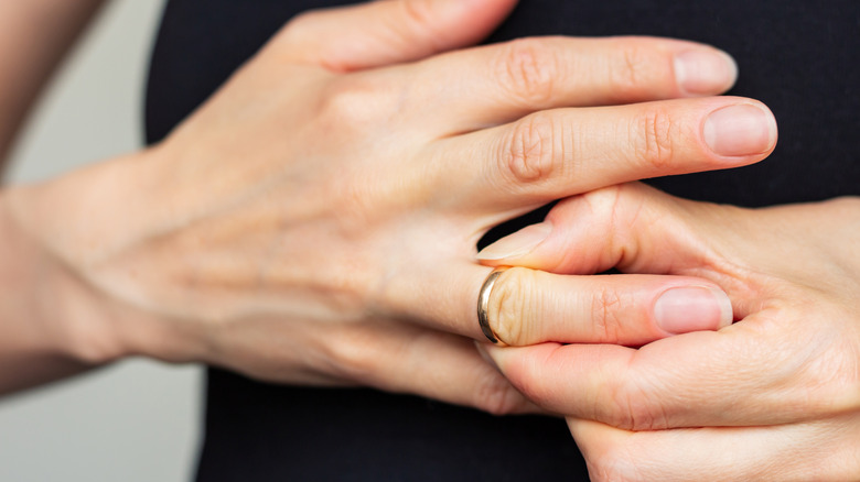 Close up of person removing a ring from their finger
