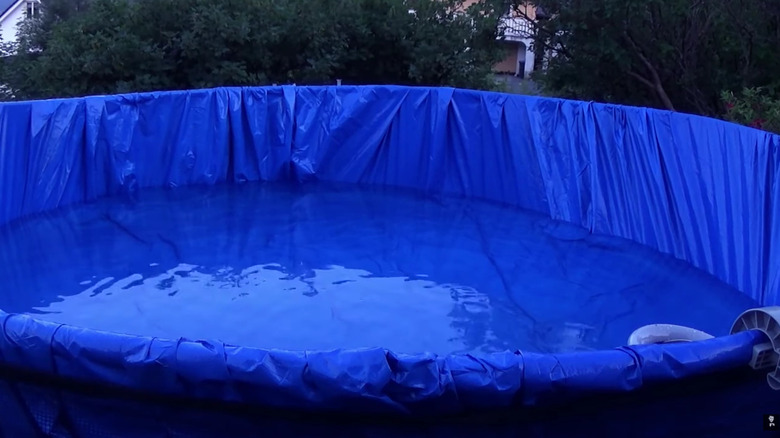 A trampoline frame upcycled into an above ground pool