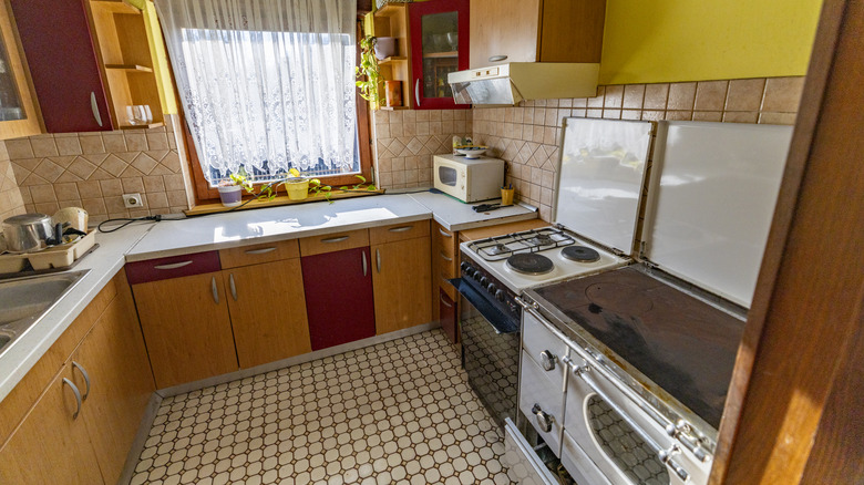 An old-fashioned kitchen with a closed floor plan and dated appliances.