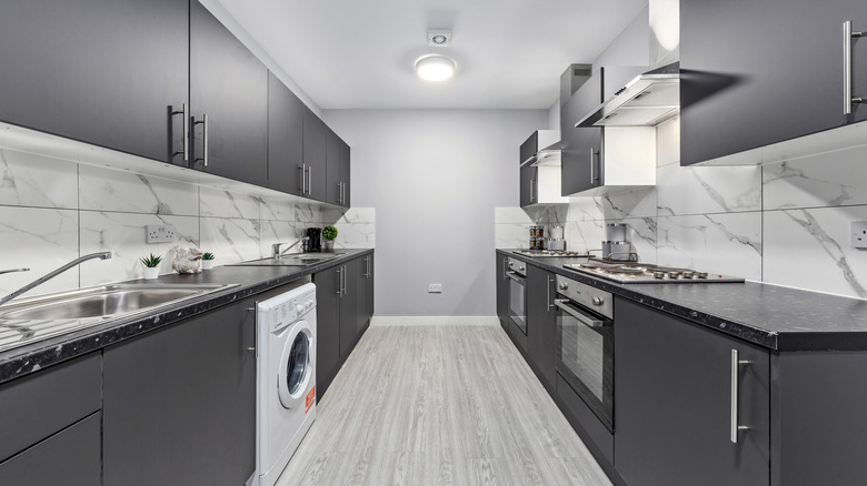 A minimalist galley kitchen with marble finishes in a modern home.