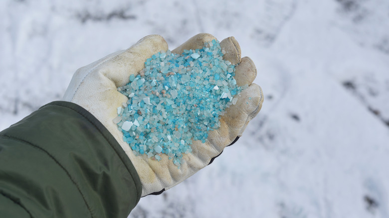 Person holding blue ice salt in a glove