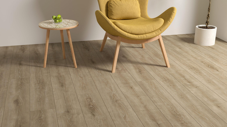 A creamy beige flooring with a yellow chair and light oak furniture
