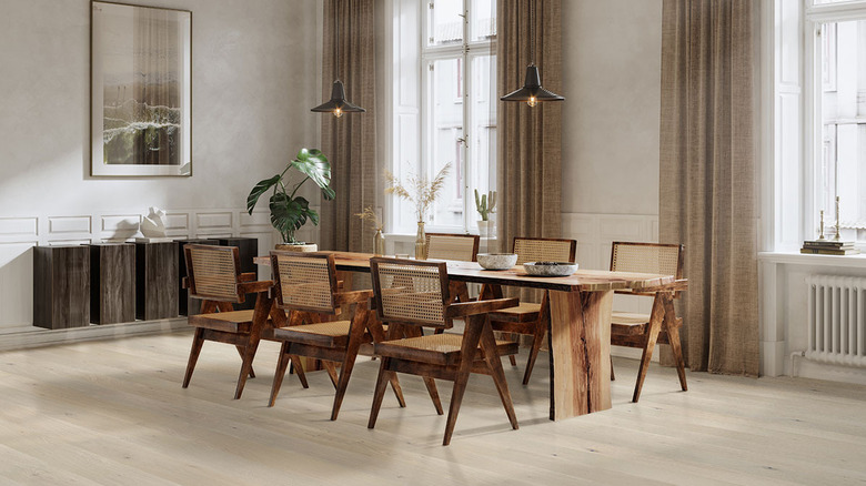 Blond wood on the floor of a large dining room with dark wood furniture and drapes, and neutral colors