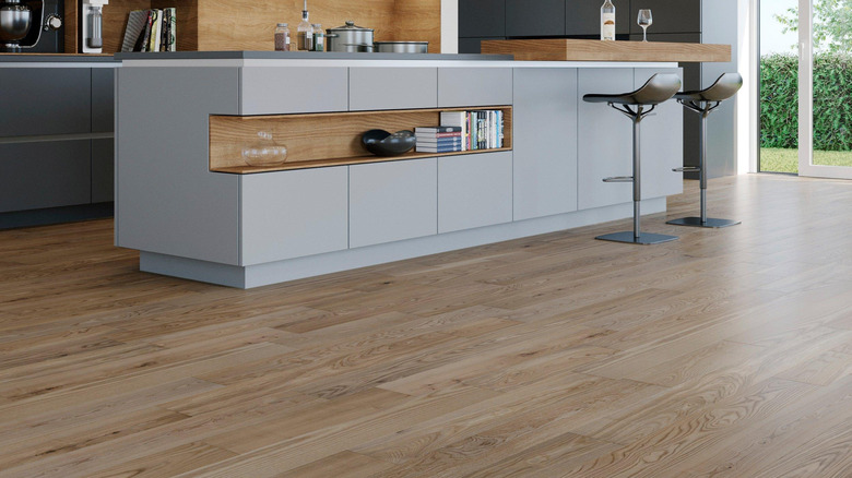 A kitchen island with a soft ash wood flooring beneath it