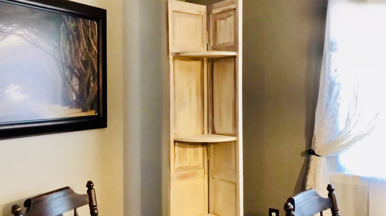 Bi-fold door is revamped as a corner shelving unit in a room.