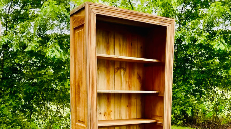Tall bookcase made from an old door has six shelves.