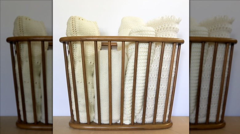 a magazine rack holding blankets