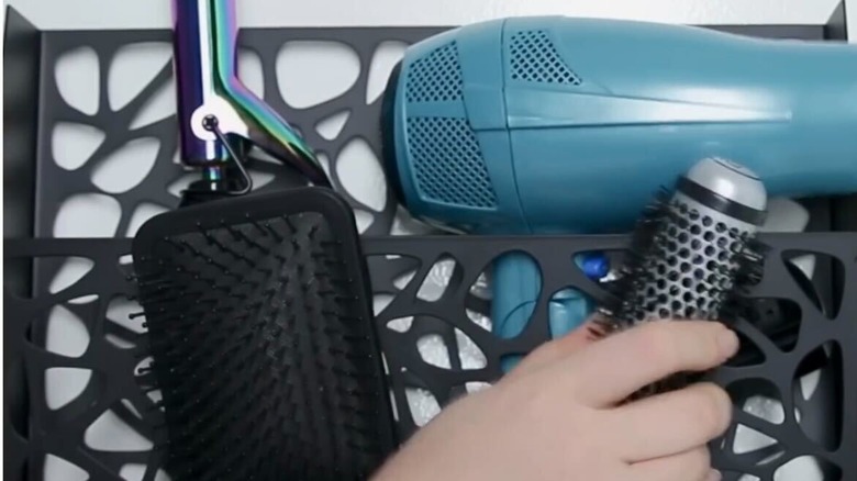 Hair styling tools stored in a magazine rack
