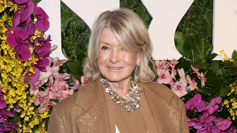 Martha Stewart smiling against a background of orchids