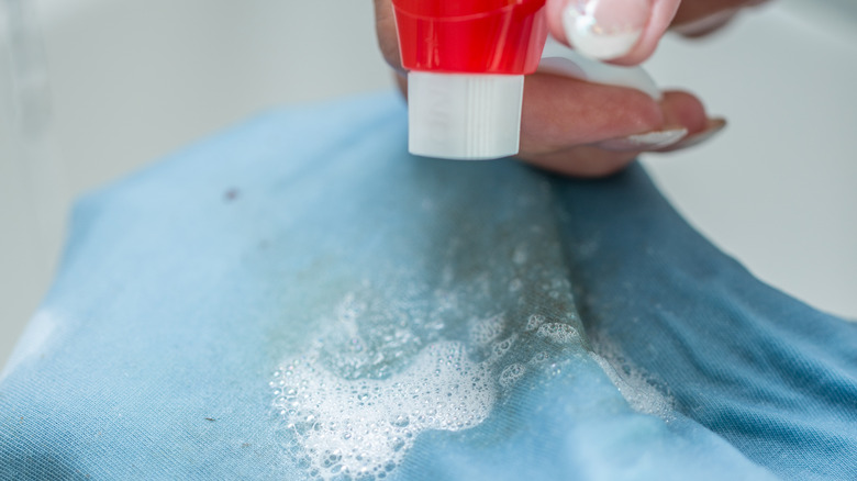Woman using a spot remover on grease stained clothing