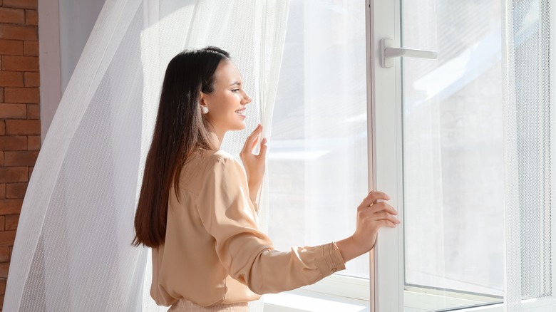 woman standing in front of open windows