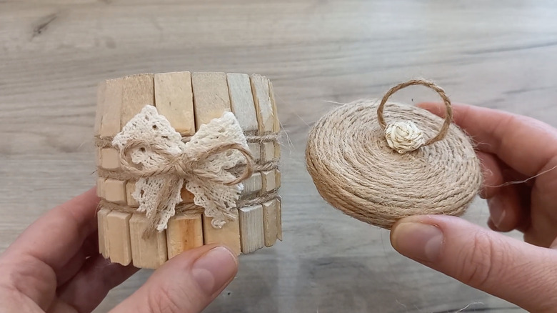 A glass jar covered in clothespins and lace with a twine lid.