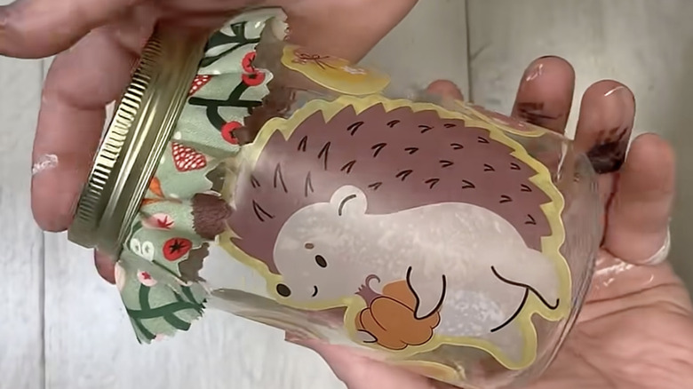 A woodland-themed jar covered with static window clings.